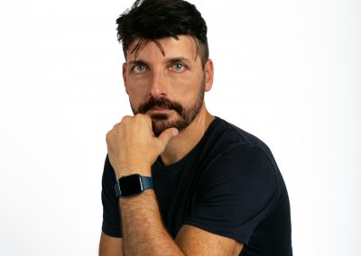 David Bello, en estudio, con fondo blanco, camiseta oscura y vaquero. Mirada frontal medio cuerpo.